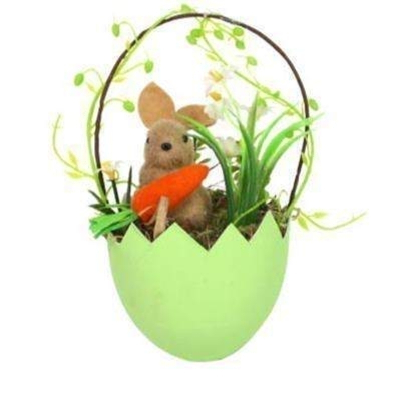 Easter bunny holding carrot sitting in an egg with articial moss and flowers. Ideal for hanging upon an easter tree. By the designer Gisela Graham who designs unique Easter decorations. (LxWxD) 18x9x8cm